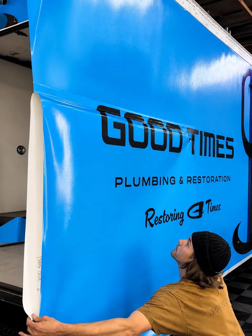 Kelton installing Good Times Plumbing and Restoration commercial graphics