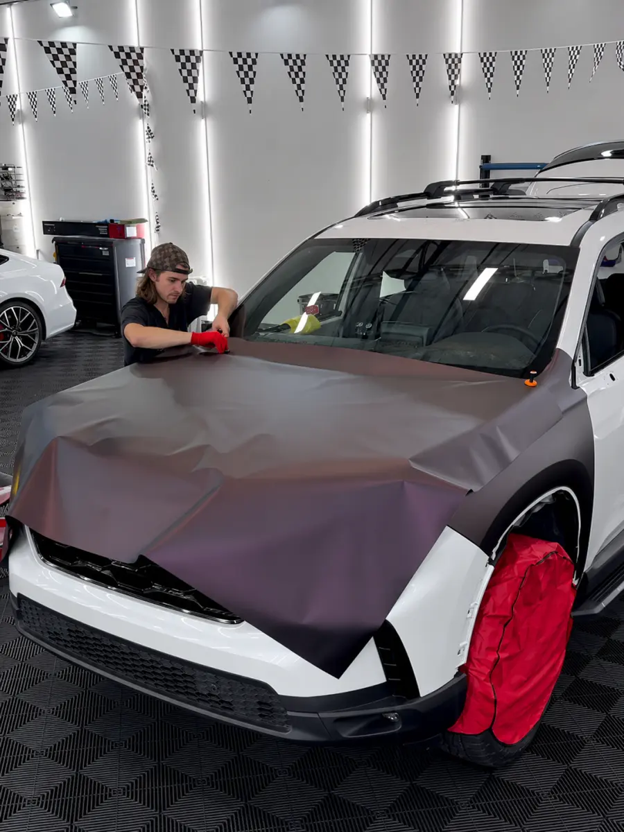 Kelton installing film on a Tesla inside the NBAUTOAZ studio